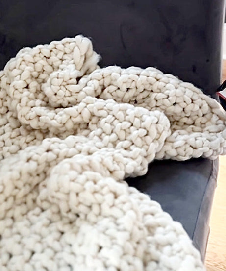 Weiche, grob gestrickte cremefarbene Überwurfdecke