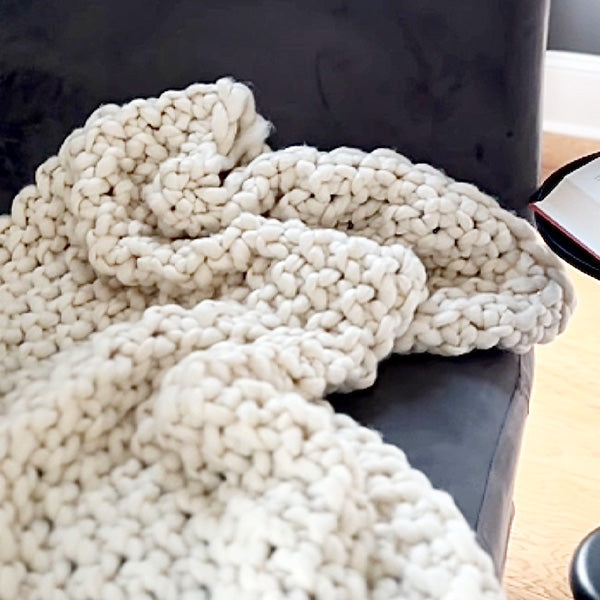 Weiche, grob gestrickte cremefarbene Überwurfdecke