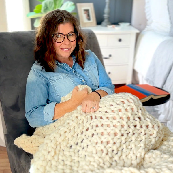 Weiche, grob gestrickte cremefarbene Überwurfdecke