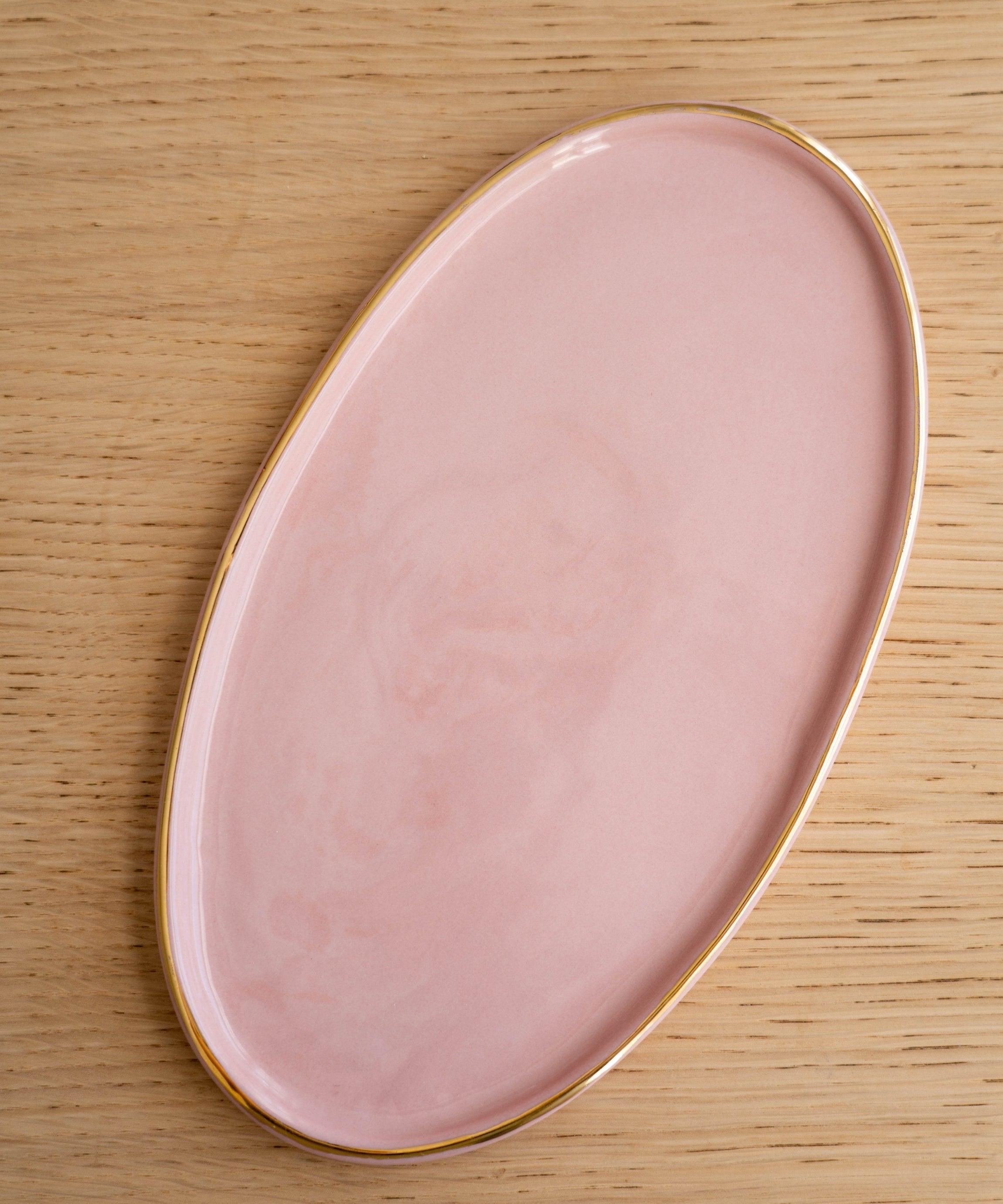 Handgefertigte ovale Porzellan-Servierplatte mit Goldrand. Puderrosa